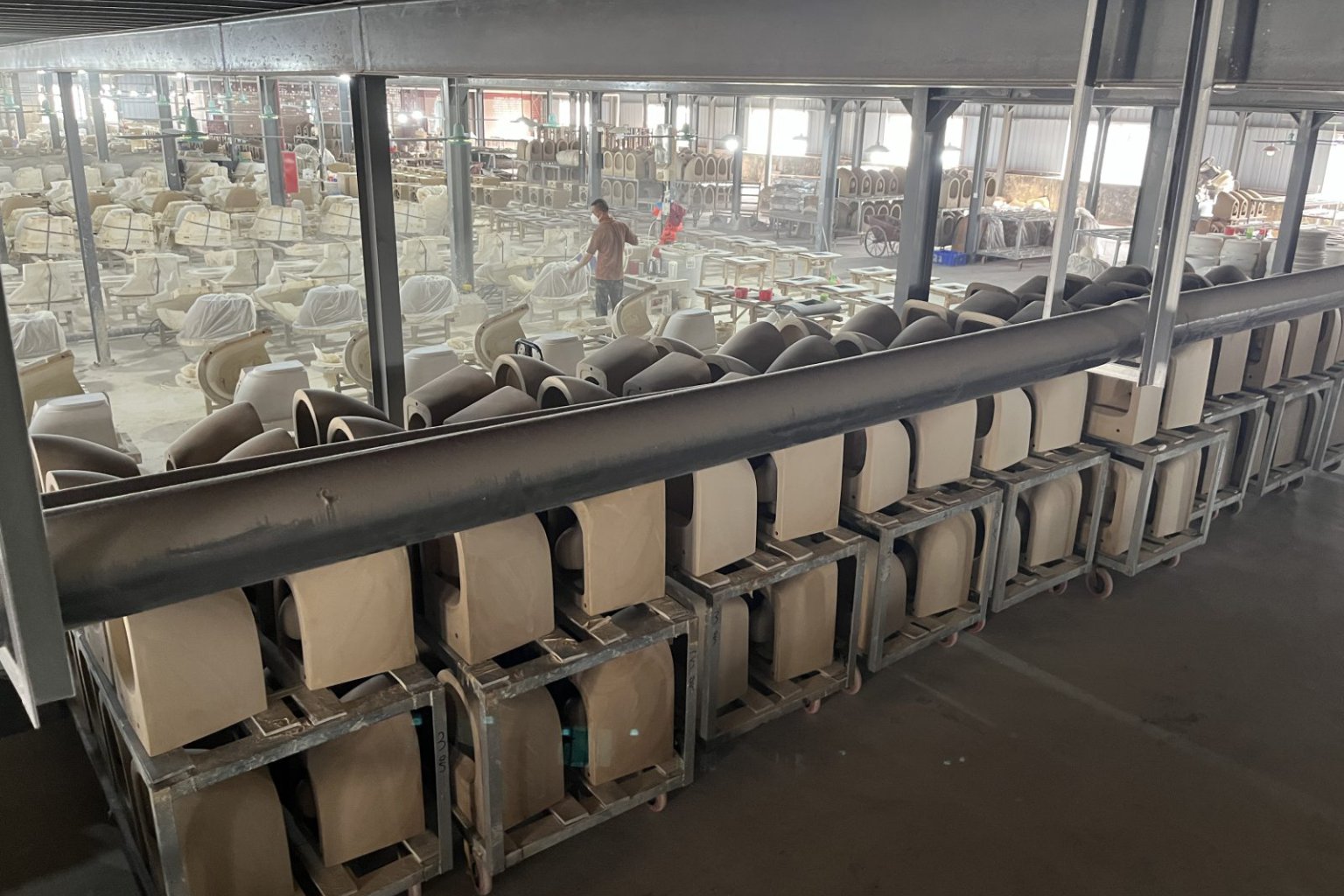 Ceramic forming line with unfinished toilet bodies on factory carts