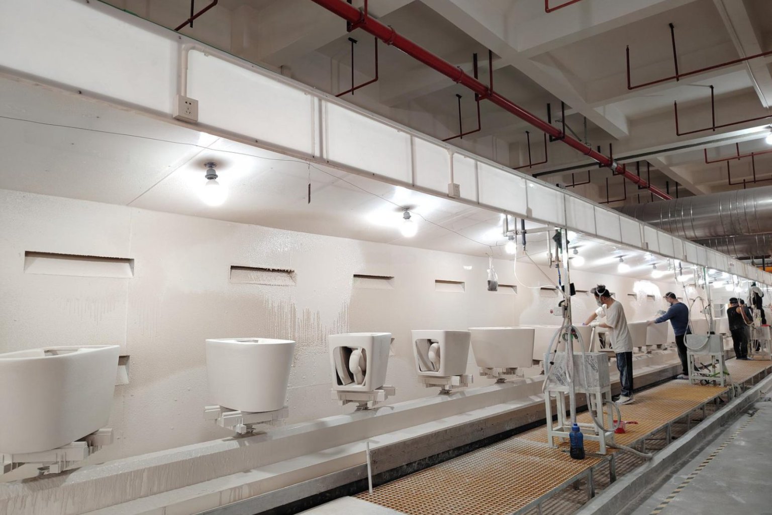Glaze coating line with technicians finishing ceramic toilets